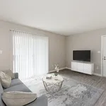 Bright and modern living room featuring a cozy gray sofa, stylish coffee table, and sleek TV setup, with abundant natural light from large sliding doors.