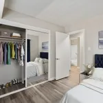 Elegant bedroom with sleek mirrored closet doors, stylish decor, and inviting ambiance, perfect for relaxation and comfort.