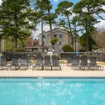 Inviting community pool with sun loungers and lush greenery, perfect for relaxation and outdoor enjoyment.