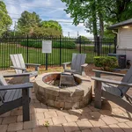 Inviting outdoor patio featuring a cozy fire pit surrounded by Adirondack chairs, perfect for social gatherings.
