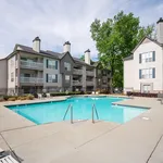 Charming apartment complex with a refreshing swimming pool, surrounded by lush greenery and elegant multi-story buildings perfect for relaxation and socializing.