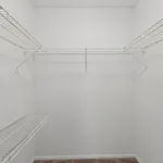 Spacious walk-in closet with sleek white wire shelving, perfect for organized storage solutions.