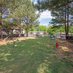 Inviting outdoor space with lush greenery, perfect for dog activities, surrounded by charming residential buildings.