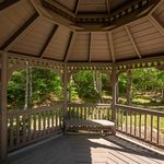 Charming wooden gazebo with stunning views of lush greenery, perfect for relaxation and outdoor enjoyment.