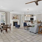 Elegant open-concept living area with chic furnishings, spacious layout, and a cozy fireplace. Perfect for entertaining and relaxation.