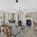Elegant living room with abundant natural light, modern furniture, and a charming fireplace, perfect for entertaining.