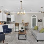 Elegant open-concept living room with modern kitchen, cozy seating, and stylish decor, perfect for relaxation and entertaining.