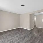Spacious and modern open-plan living area with elegant wood-style flooring and soft neutral walls, perfect for versatile decor.