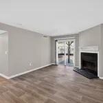 Elegant living room featuring modern hardwood flooring, a cozy fireplace, and sliding glass doors opening to a balcony with a view.