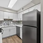Modern kitchen with sleek stainless steel appliances, elegant white cabinetry, and stylish mosaic backsplash.