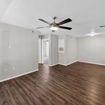 Modern apartment with elegant wood flooring and open space, featuring a ceiling fan and ambient lighting.