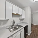 Modern kitchen with sleek white cabinetry, elegant countertop, double stainless steel sink, and spacious layout.
