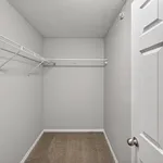 Spacious walk-in closet with built-in shelving in a modern apartment, perfect for organizing clothes and accessories.