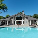 Inviting clubhouse with modern architecture and a sparkling pool, perfect for relaxation and social gatherings.
