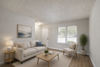 Bright and inviting living room with modern cream furniture, stylish decor, and large window for natural light.