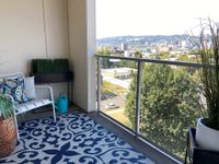Space to Relax, Room to Breathe Charming balcony retreat with vibrant decor, offering stunning city views and lush greenery.