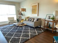 Modern Interiors, Thoughtfully Designed Chic living room with cozy gray sofa, modern decor, and large windows flooding the space with natural light.