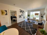 Modern Living with a Cozy Touch Bright and modern living room with chic decor, large windows, and cozy bedroom view, ideal for urban living.