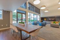Your Space for Social Moments Inviting and modern communal living space with high ceilings, abundant natural light, chic décor, and stylish seating, perfect for social gatherings.