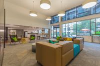 Every Amenity, Thoughtfully Curated Chic and inviting modern living space with large windows, stylish seating, and vibrant decor overlooking a lush exterior.