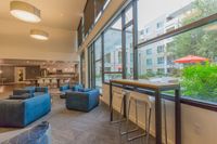 Spaces That Inspire Connection Bright and modern lounge area with large windows, stylish seating, and a view of a vibrant courtyard.