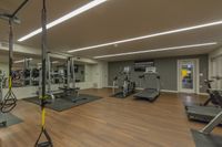 Your Gym, Just Steps from Home Modern fitness center featuring state-of-the-art exercise equipment, including treadmills and weight machines, on sleek wood flooring.