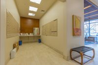 Delivery Made Simple Bright and welcoming apartment mailroom with modern design, featuring spacious mailboxes, elegant artwork, and abundant natural light.