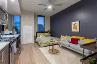 Modern studio apartment showcasing an open layout with a stylish kitchen, cozy sleeping area, and inviting living space featuring contemporary decor.