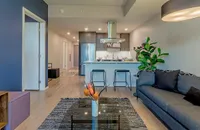 Contemporary open-concept apartment interior with sleek kitchen, stylish living area, and modern décor.