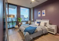 Elegant bedroom with a city view, featuring chic decor, cozy bedding, and modern furnishings.