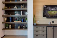Modern living room showcasing elegant shelving with decorative accents, a sleek entertainment unit, and a mounted television, perfect for stylish urban living.