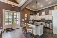 Chic kitchen design with elegant pendant lighting, modern bar stools, and a sleek island for a luxurious living space.