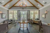Elegant community lounge with vaulted ceilings, modern chandelier, and comfortable seating areas, perfect for relaxation and social gatherings.