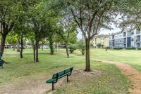 Sunshine, Shade, and Space to Spare Tranquil park setting with lush greenery, a walking path, and nearby modern apartments, perfect for relaxation and enjoying nature.