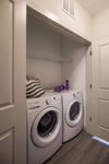Every Nook Has a Purpose Modern laundry nook with energy-efficient washer and dryer seamlessly integrated into a cozy apartment space.