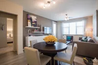 Gather Around the Table Bright and modern open-plan living room with elegant dining area, stylish decor, and ample natural light.