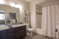 Spa-Like Bathrooms Elegant bathroom featuring chic granite countertops, modern lighting, and stylish decor with a relaxing bathtub and shower.