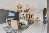 Designed to Impress Elegant and modern living area featuring chic chandeliers, stylish seating, and contemporary decor with a bright and inviting atmosphere.