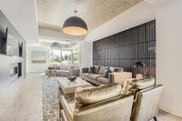 Gather. Relax. Unwind. Elegant living room showcasing modern decor with plush sofas, chic lighting, and a cozy fireplace, ideal for relaxation and entertainment.