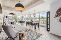 Your Space for Social Moments Modern lounge area with elegant armchairs, stylish wooden tables, and large windows offering scenic views, ideal for relaxation and social gatherings.