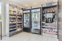 Marketplace convenience Modern apartment convenience store with stocked snack shelves, refrigerated beverages, and a self-checkout station, offering a bright and welcoming shopping experience.
