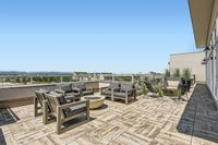 Soak Up the Sun—or the Stars Expansive rooftop terrace with modern outdoor furniture, offering scenic city views and a perfect setting for relaxation and entertainment.
