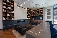 Luxurious lounge area with elegant shelving, plush seating, and ambient lighting, perfect for relaxation in a modern apartment complex.