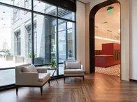 Modern apartment lobby with stylish seating area, large windows, and a sleek mailroom entrance, offering a welcoming and contemporary design.