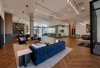 Sophisticated lounge area with modern lighting, stylish blue sofas, and sleek wooden flooring for a contemporary aesthetic.