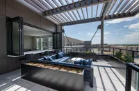 Chic urban rooftop patio featuring modern outdoor seating, stylish pergola with a city view, and abundant natural light perfect for relaxation.