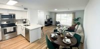 Style That Flows from Kitchen to Table Modern open-plan kitchen and living space with elegant dining area, stainless steel appliances, and a bright, inviting atmosphere.