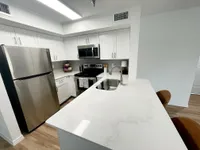 Functionality That Feels Effortless Modern kitchen with sleek stainless steel appliances, elegant white cabinetry, and a luxurious marble countertop.
