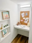 Quiet Corners for Big Ideas Charming home office nook with bright lighting, inspiring corkboard, decorative art, and elegant shelving.