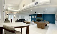 Community Starts Here Modern lounge area featuring high ceilings, a stylish pool table, comfortable seating, and an inviting fireplace.